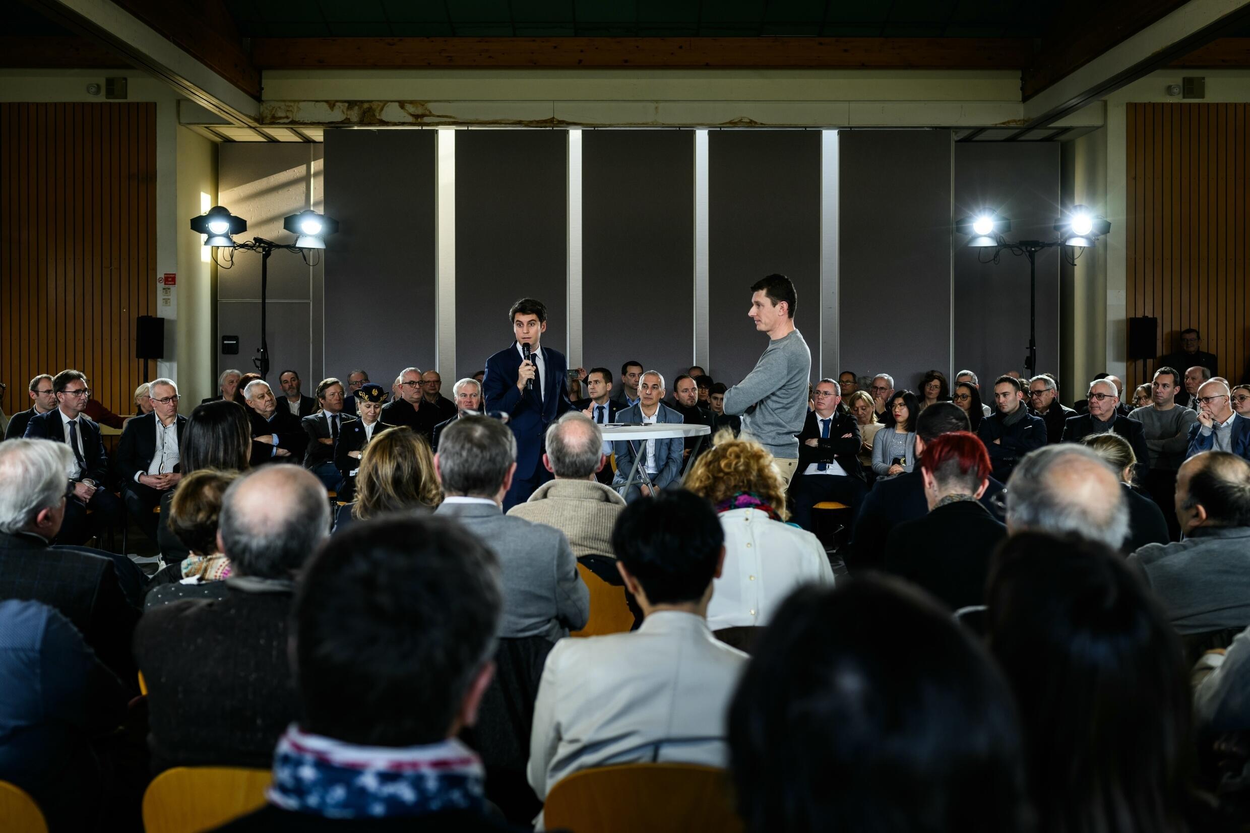 Le Premier ministre Gabriel Attal (G) lors d'un débat avec des maires et des habitants, le 20 janvier 2024 à Saint-Laurent d'Agny, dans le Rhône